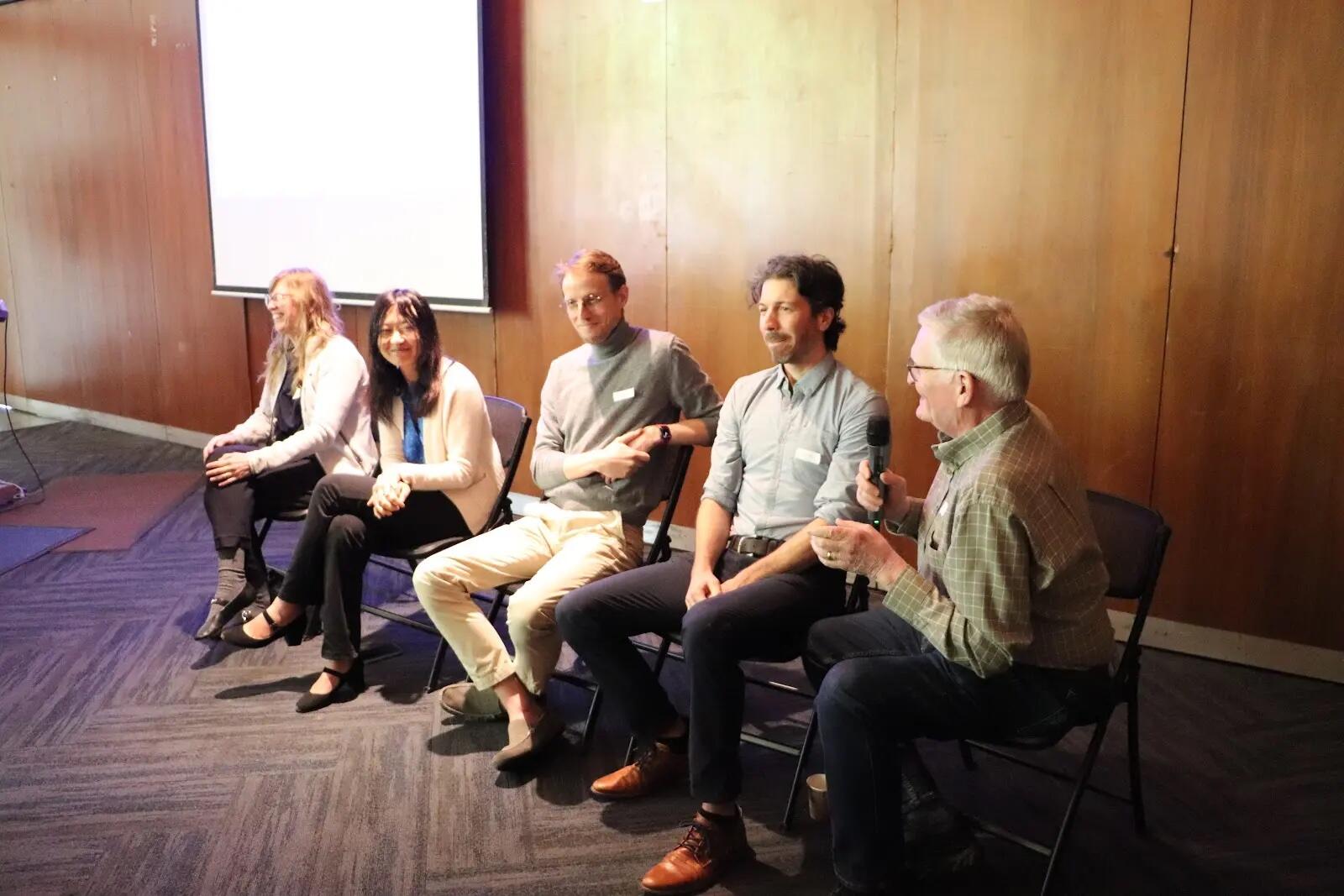 Liberty Hamilton, Doris Tsao, Alex Huth, Jacob Yates, and Robert Knight are sitting in front of an audience, smiling, while Knight speaks into a microphone.